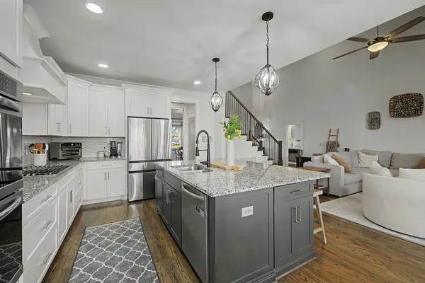 a kitchen with granite countertop white cabinets and a stove