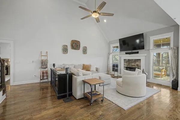 a living room with furniture kitchen view and a chandelier