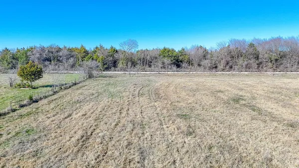a view of a field with trees in background