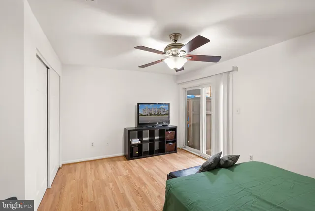 a bedroom with a bed and a flat tv screen on a dresser