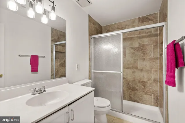 a bathroom with a sink vanity mirror and toilet