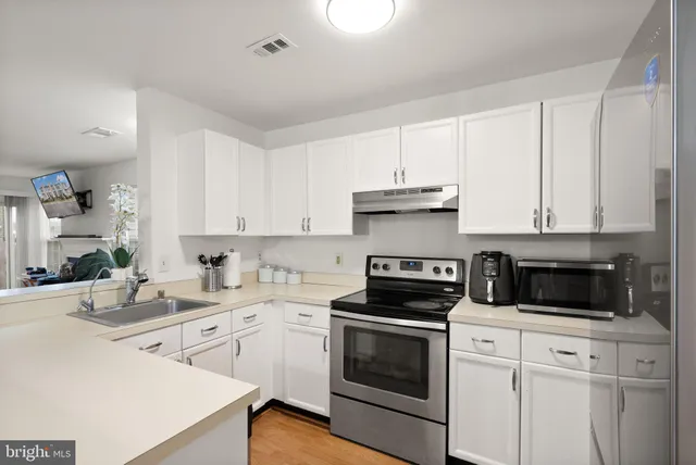 a kitchen with cabinets appliances a sink and a counter top space