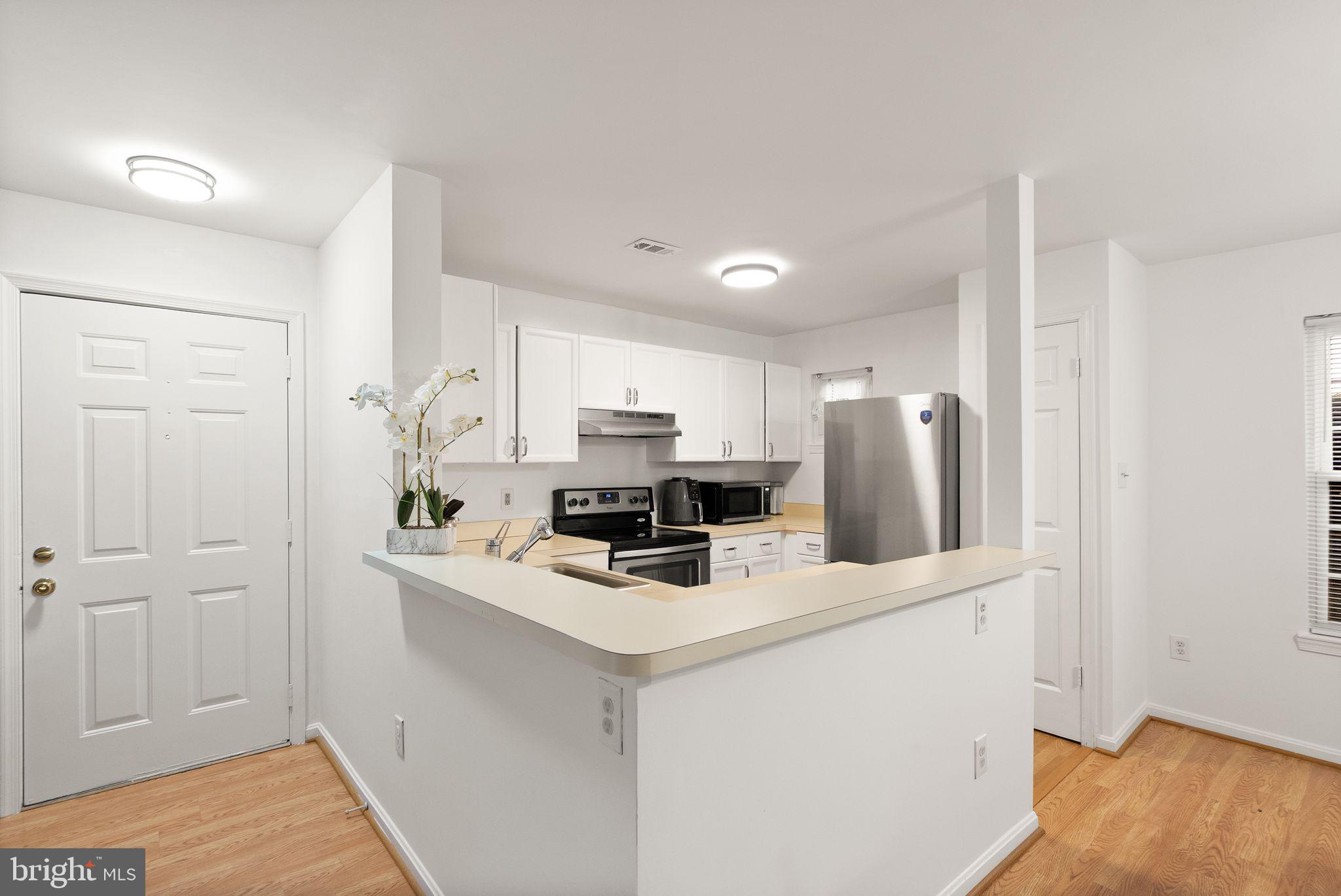 8003 Copperfield Way Manassas, VA 20109 - Photo 3 of 27 a kitchen with stainless steel appliances a refrigerator a stove a sink and white cabinets