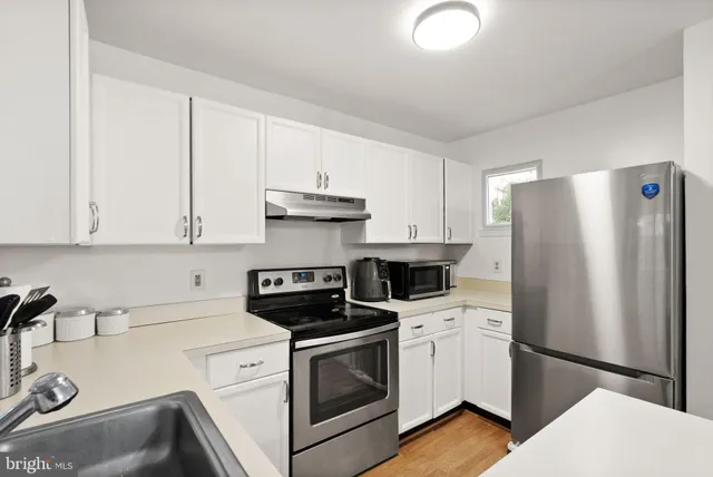 a kitchen with white cabinets and white appliances