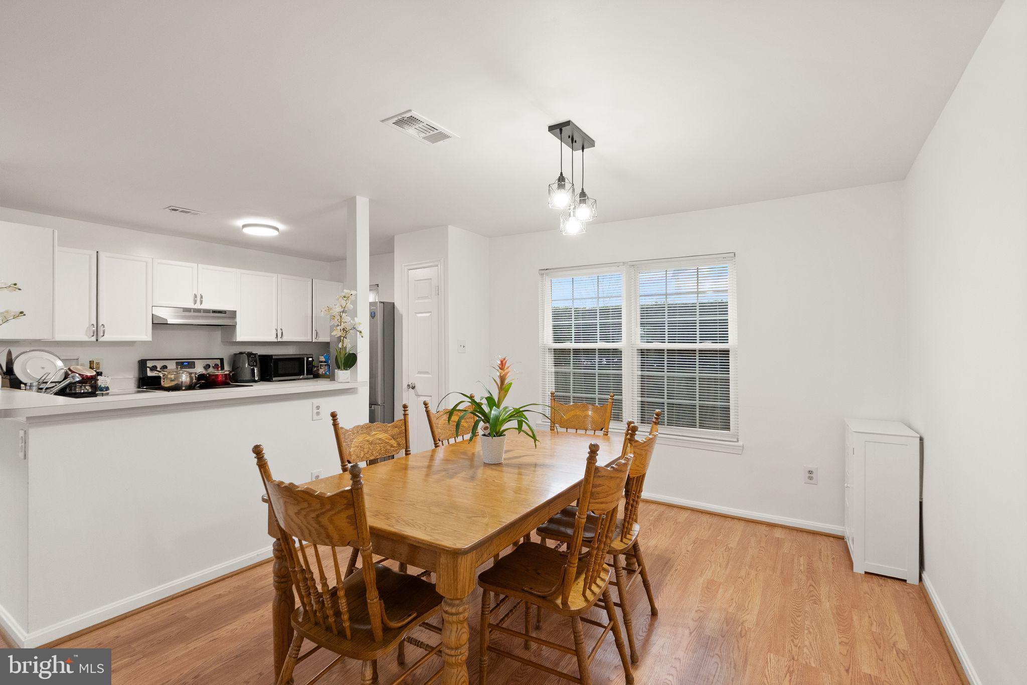 8003 Copperfield Way Manassas, VA 20109 - Photo 6 of 27 a view of a dining room with furniture and wooden floor