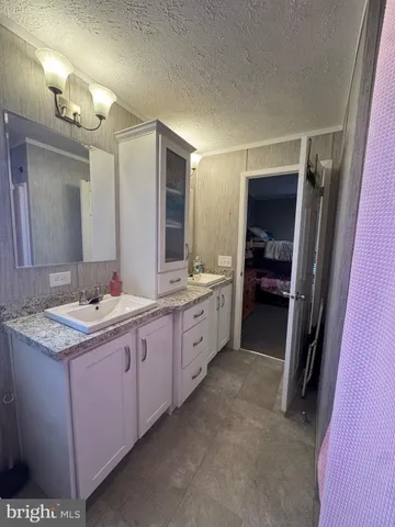 a spacious bathroom with a granite countertop sink mirror and a