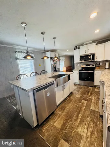 a kitchen with stainless steel appliances kitchen island granite countertop a stove a sink and a microwave