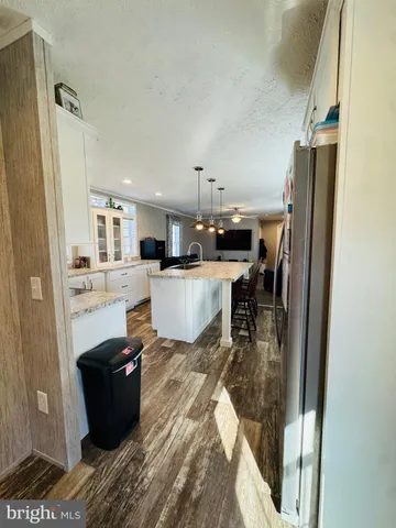 a kitchen with stainless steel appliances granite countertop a refrigerator a stove a sink a dining table and chairs