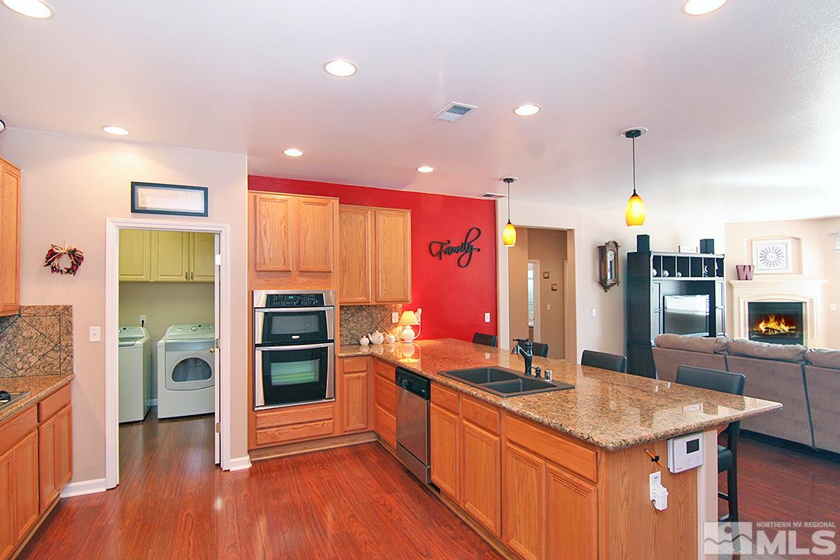 10860 Rushing Flume Drive Reno, NV 89521 - Photo 6 of 23 a kitchen with stainless steel appliances granite countertop a sink stove and refrigerator