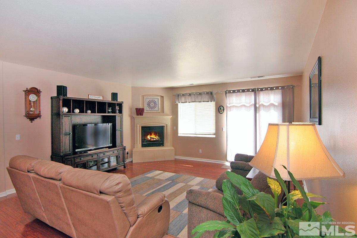 10860 Rushing Flume Drive Reno, NV 89521 - Photo 8 of 23 a living room with furniture a flat screen tv and a fireplace
