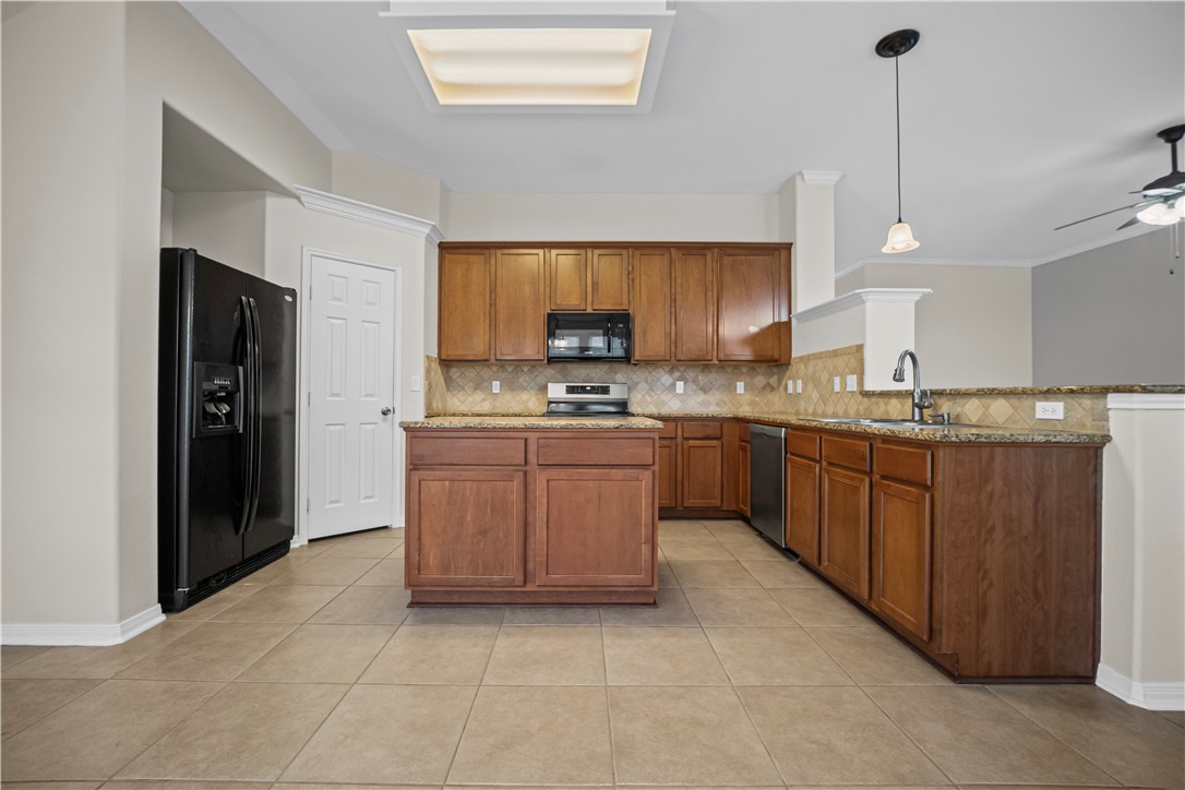 7509 Exeter Corpus Christi, TX 78414 - Photo 7 of 29 a kitchen with stainless steel appliances granite countertop a stove a sink and a refrigerator