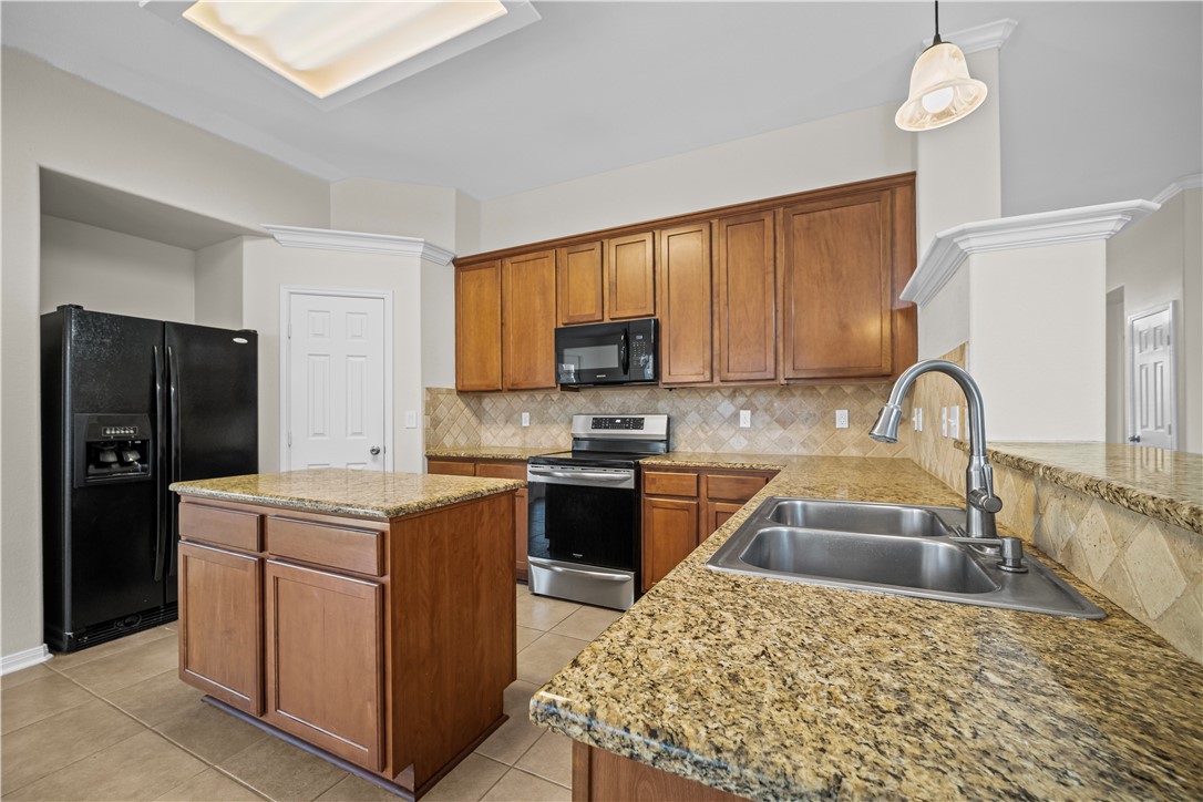 7509 Exeter Corpus Christi, TX 78414 - Photo 9 of 29 a kitchen with a sink stove and refrigerator