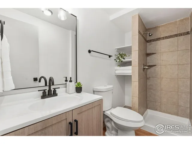 a bathroom with a sink a toilet a mirror and shower