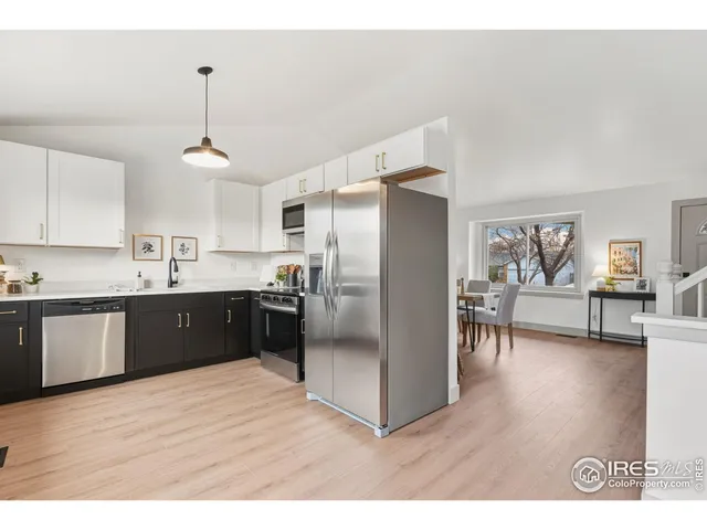 a kitchen with stainless steel appliances granite countertop a refrigerator a sink dishwasher a stove with wooden floor