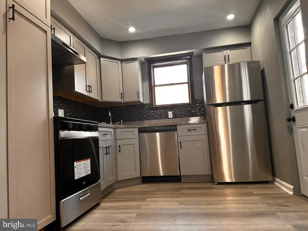 a kitchen with stainless steel appliances granite countertop a refrigerator a sink and a stove