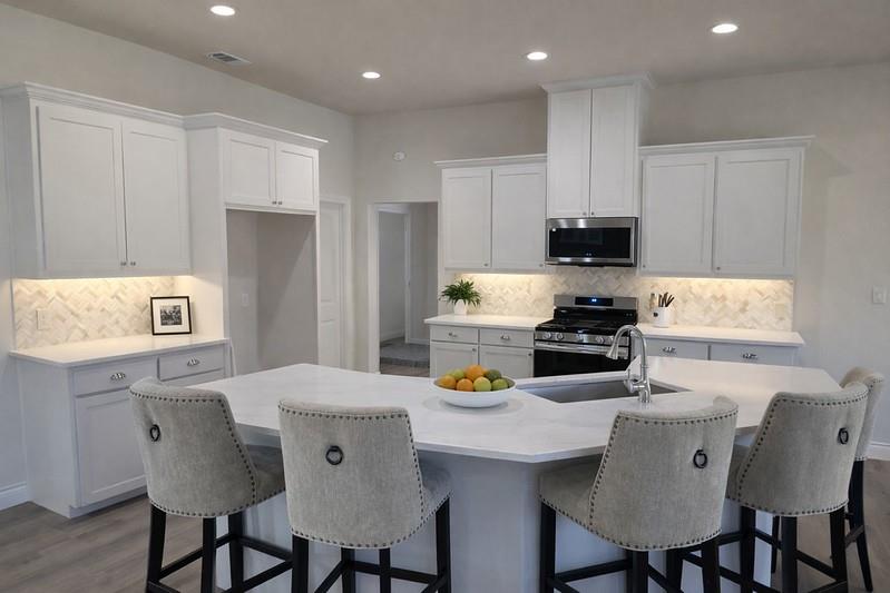 25 Pear Tree Lane Collinsville, TX 76233 - Photo 9 of 34 a kitchen with stainless steel appliances a dining table chairs and refrigerator