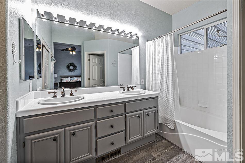 9685 Boulder Creek Lane Reno, NV 89521 - Photo 21 of 22 a bathroom with a double vanity sink a mirror and a bathtub
