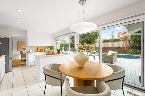 a dining room with furniture a chandelier and wooden floor