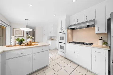 a kitchen with white cabinets and appliances