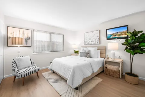 a bedroom with a bed and a potted plant