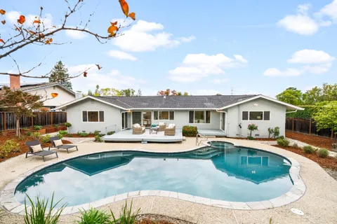a view of a house with backyard and sitting area