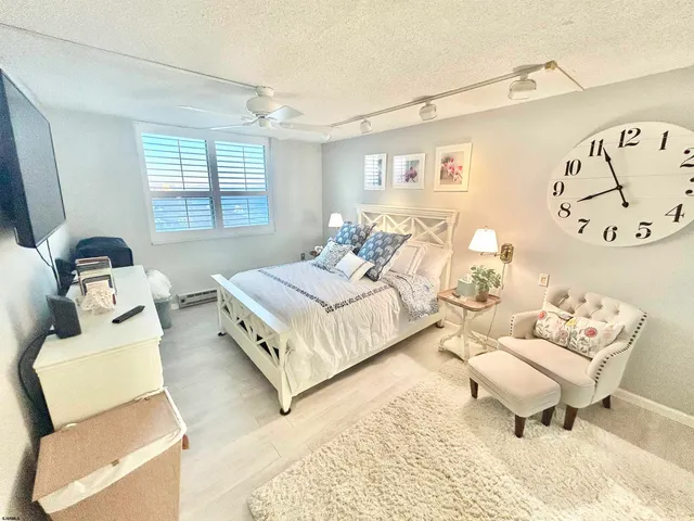 a spacious bedroom with a bed and wooden floor