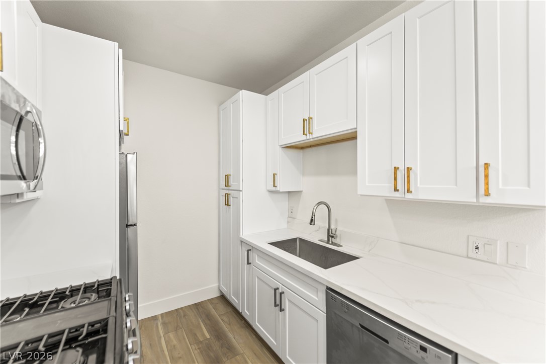 4730 East Craig Road, Unit 1053 Las Vegas, NV 89115 - Photo 6 of 32 A streamlined kitchen showcasing bright white cabinetry, sleek countertops, and modern appliances.