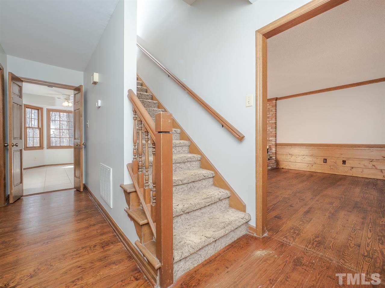 8317 Druids Lane Raleigh, NC 27613 - Photo 5 of 24 The main foyer has a staircase, heart pine flooring and is open to other areas of the downstairs.