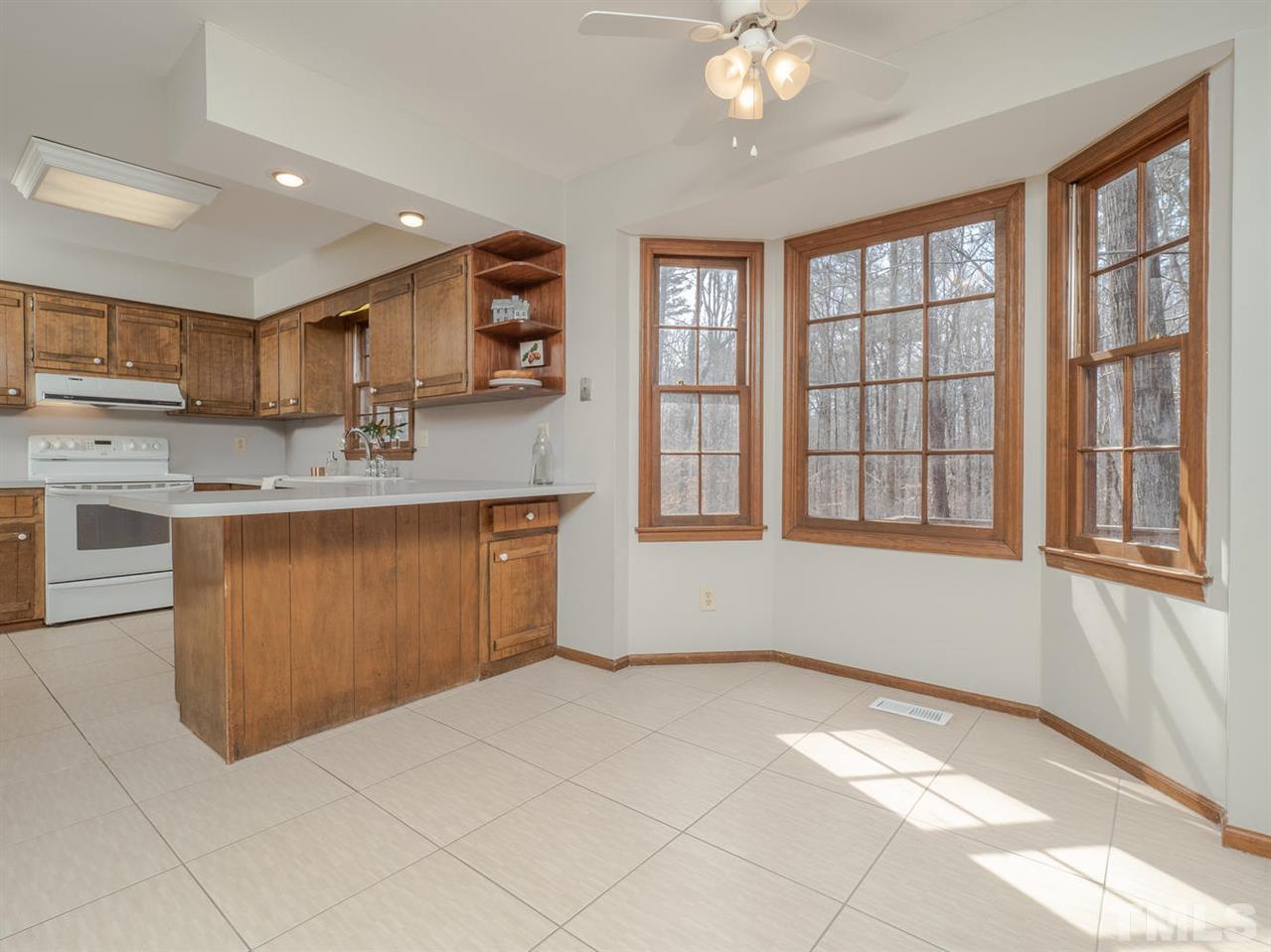 8317 Druids Lane Raleigh, NC 27613 - Photo 9 of 24 Large kitchen with breakfast nook situated in front of a bay window.