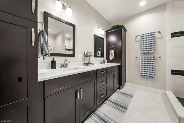 a spacious bathroom with double vanity sink two mirror and a shower
