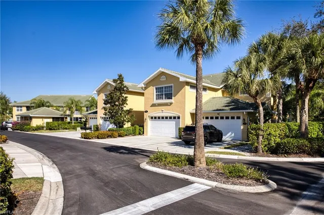 a front view of a house with garden and trees
