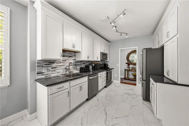 a kitchen with stainless steel appliances granite countertop a stove refrigerator and cabinets