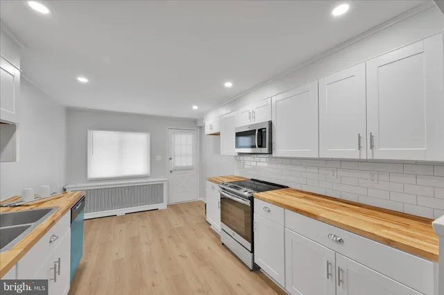 a kitchen that has a sink and a stove top oven