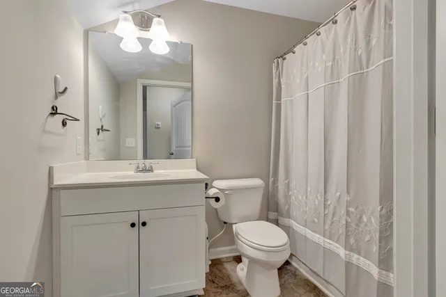 a bathroom with a toilet a sink and a mirror