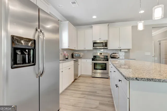 a kitchen with granite countertop a refrigerator oven a sink and dishwasher