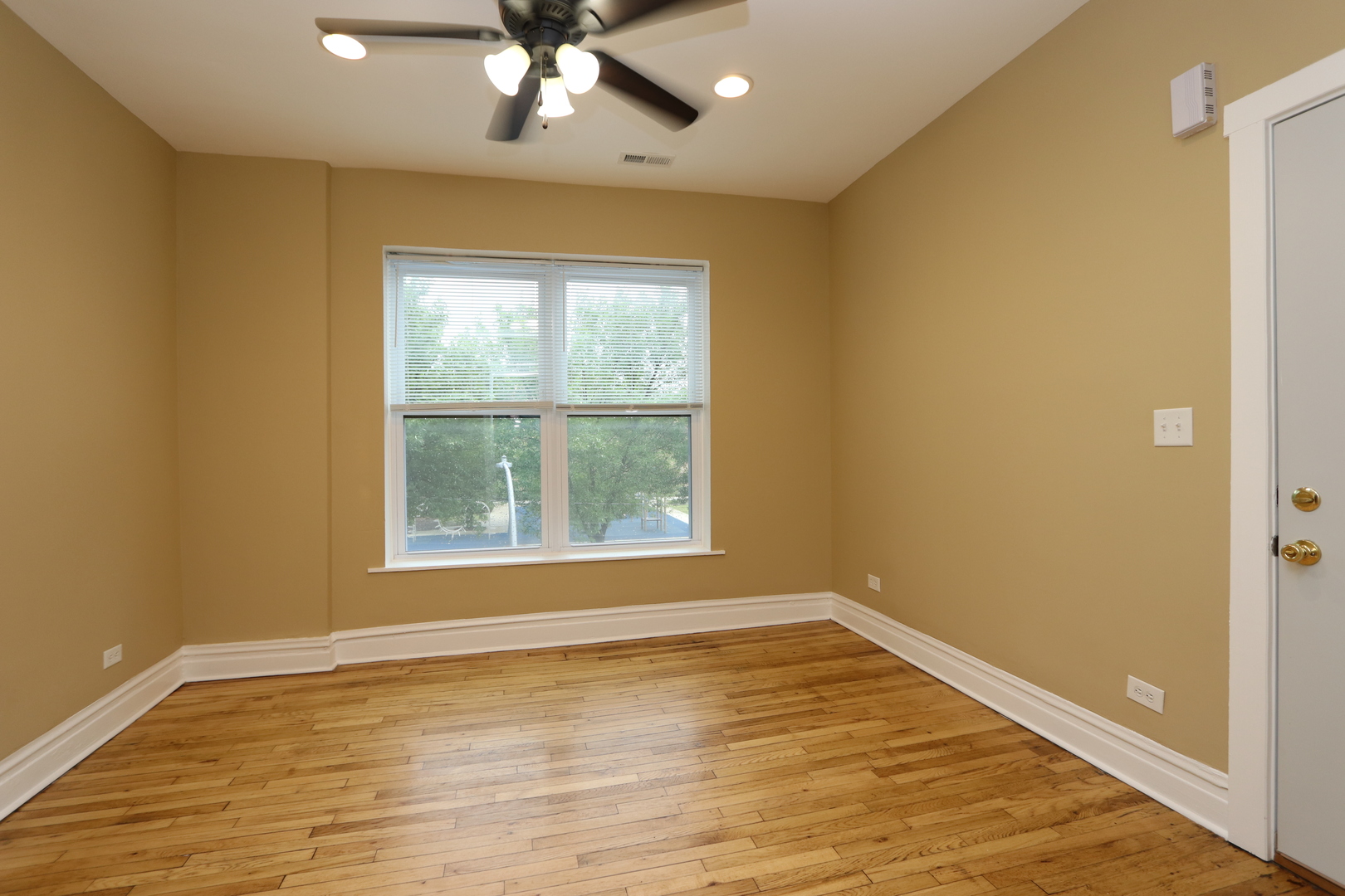 934 North Lamon Avenue, Unit 2 Chicago, IL 60651 - Photo 2 of 7 a view of an empty room with wooden floor and a window
