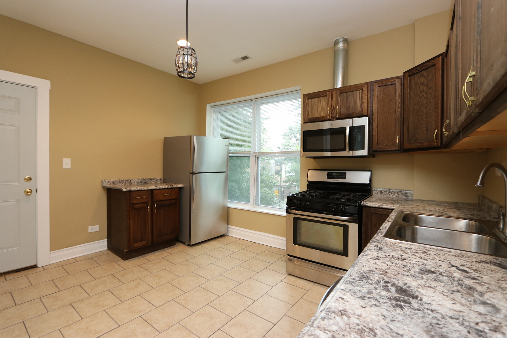 934 North Lamon Avenue, Unit 2 Chicago, IL 60651 - Photo 4 of 7 a kitchen with stainless steel appliances granite countertop a stove top oven a sink dishwasher a refrigerator and a microwave
