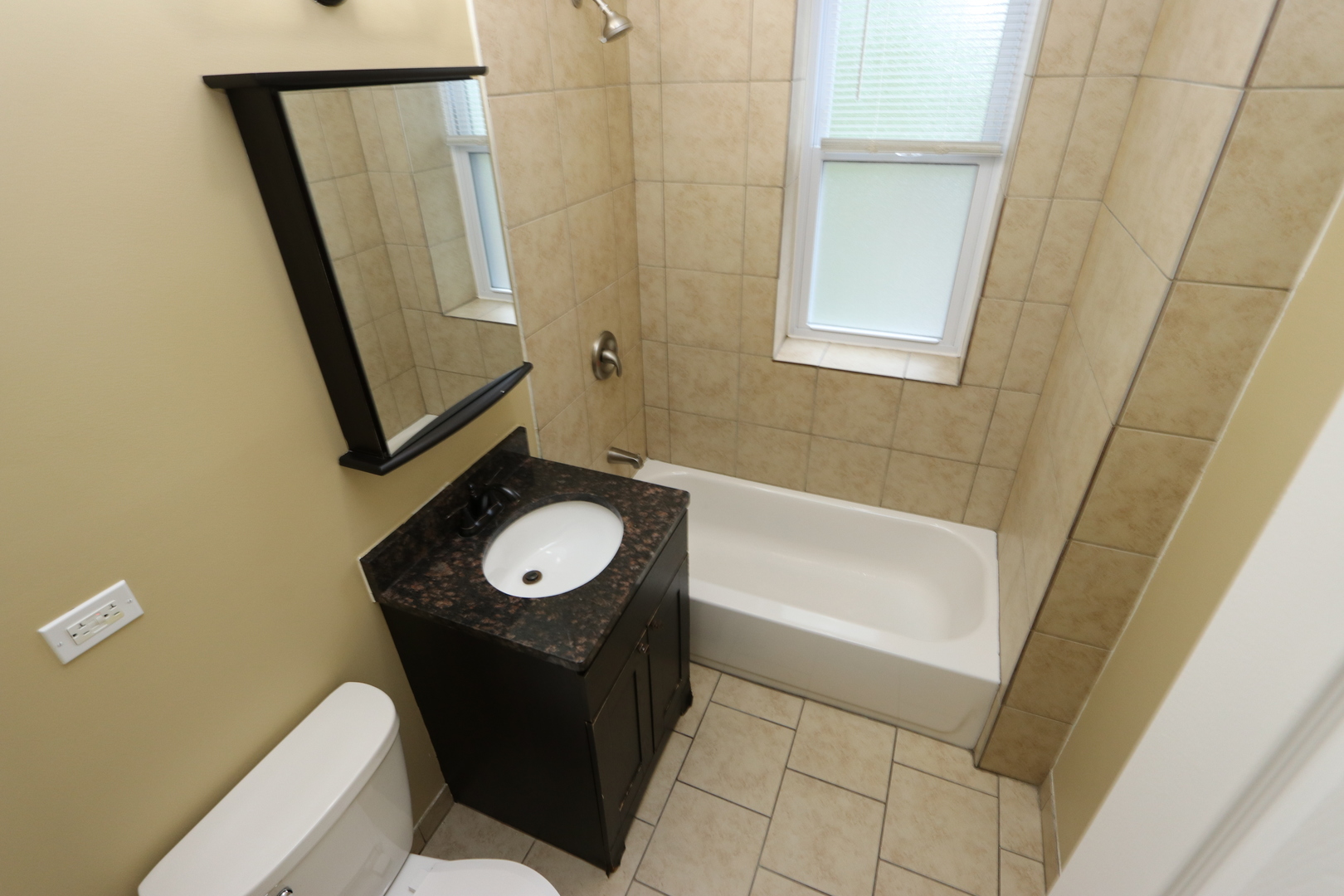 934 North Lamon Avenue, Unit 2 Chicago, IL 60651 - Photo 5 of 7 a bathroom with a sink a toilet and a mirror