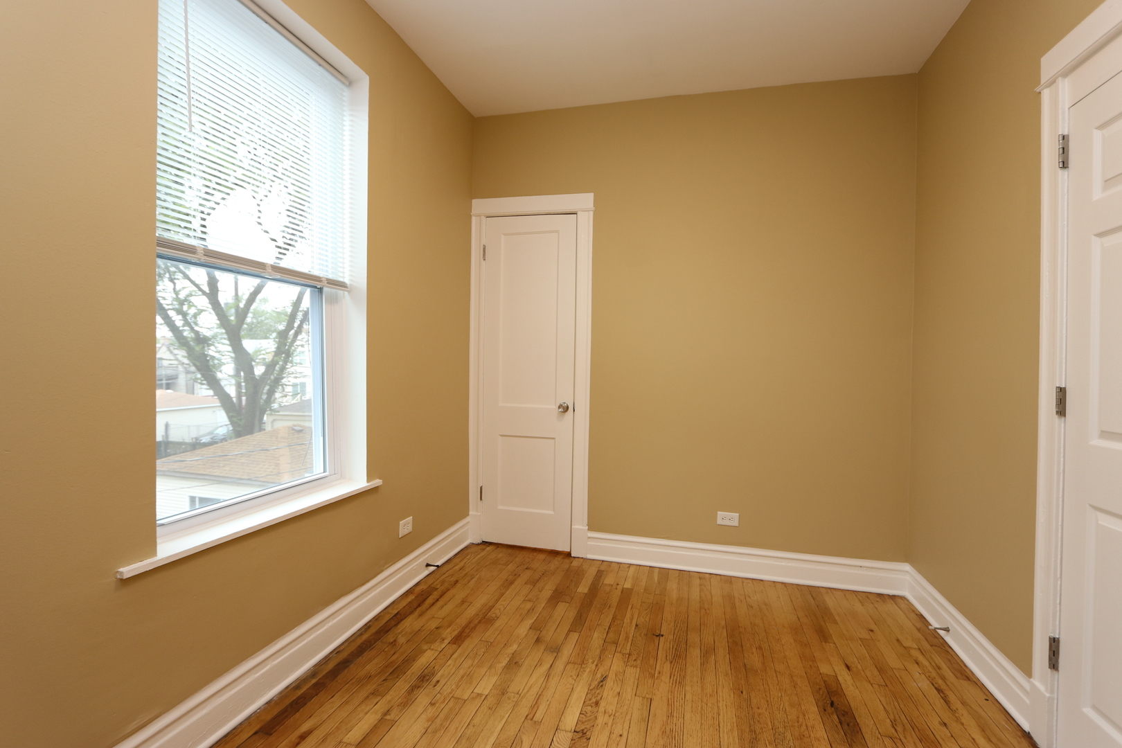 934 North Lamon Avenue, Unit 2 Chicago, IL 60651 - Photo 7 of 7 a view of an empty room with wooden floor and a window