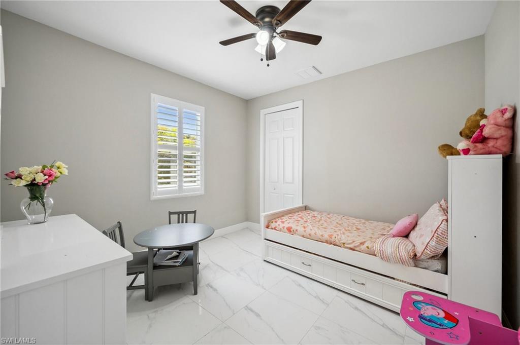 3407 20th Street Southwest Lehigh Acres, FL 33976 - Photo 17 of 23 a bedroom with a bed and a table