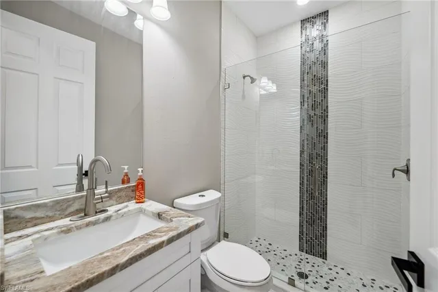 a bathroom with a sink toilet vanity and shower