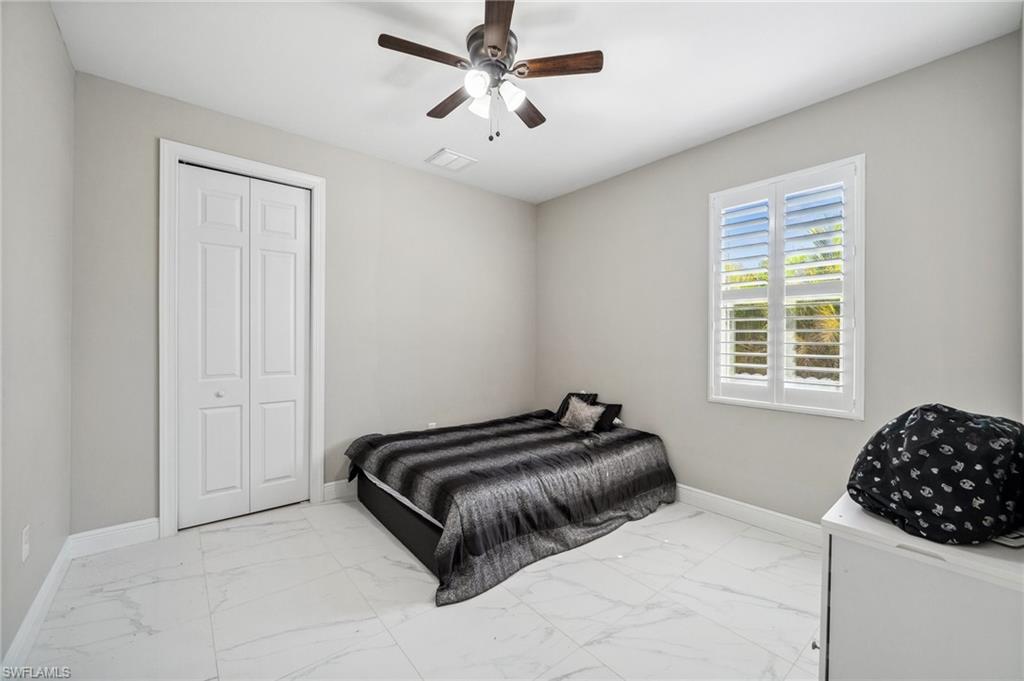 3407 20th Street Southwest Lehigh Acres, FL 33976 - Photo 19 of 23 a bedroom with a bed and a chandelier