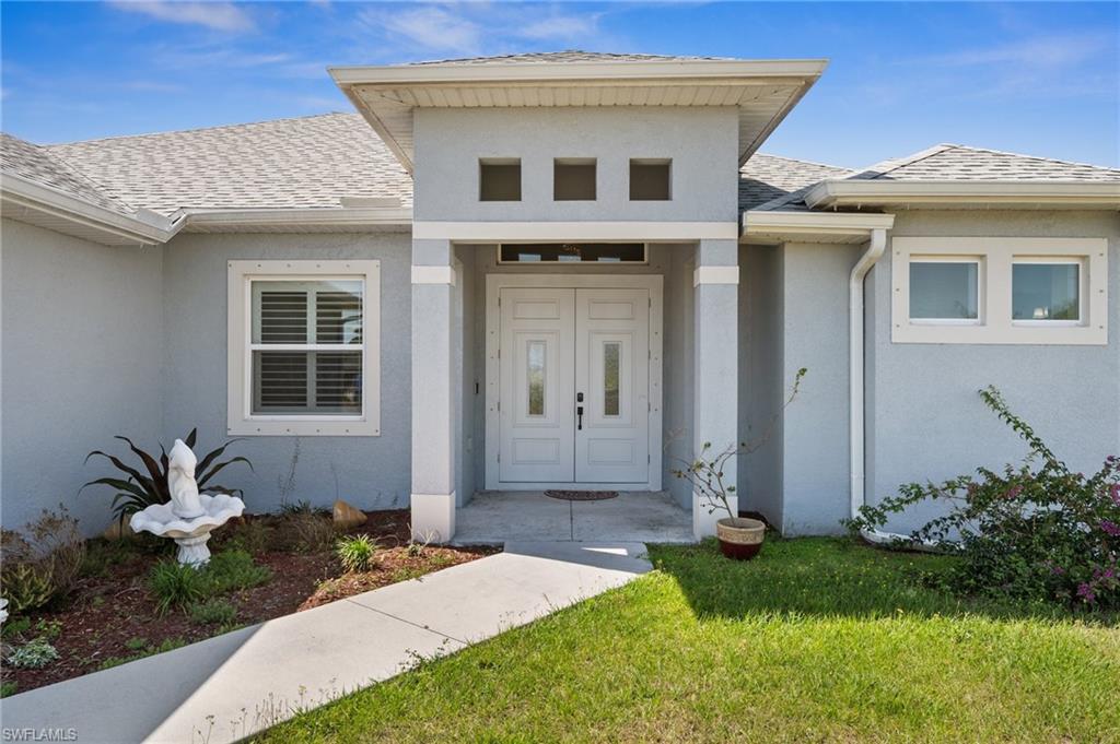 3407 20th Street Southwest Lehigh Acres, FL 33976 - Photo 2 of 23 a front view of a house with garden
