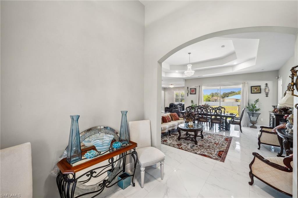 3407 20th Street Southwest Lehigh Acres, FL 33976 - Photo 4 of 23 a living room with furniture a rug and gym equipment