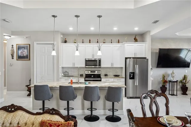a kitchen with stainless steel appliances kitchen island granite countertop a refrigerator and a stove top oven