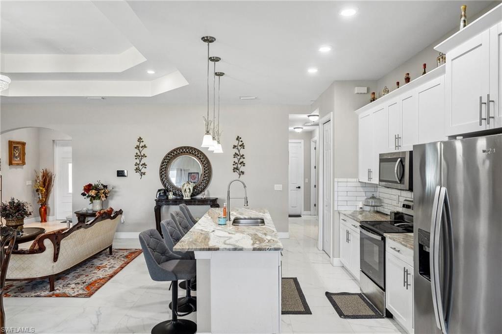 3407 20th Street Southwest Lehigh Acres, FL 33976 - Photo 8 of 23 a kitchen with granite countertop a sink stainless steel appliances and cabinets