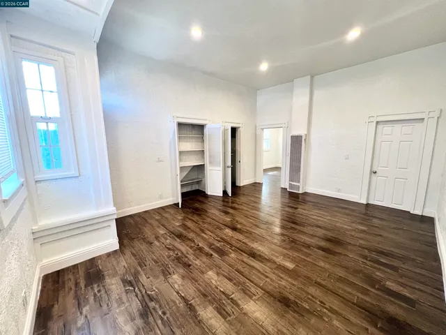 a view of a kitchen with wooden floor and a refrigerator