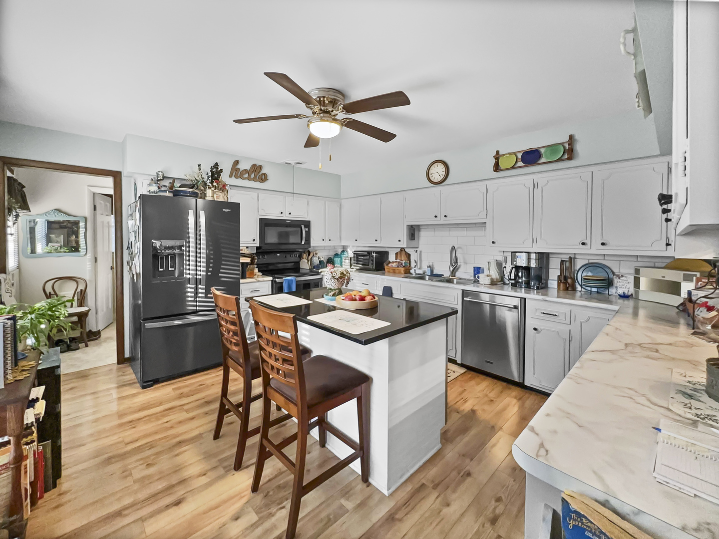 447 South Ralph Street Watseka, IL 60970 - Photo 9 of 20 a kitchen with stainless steel appliances a stove a sink dishwasher a refrigerator with white cabinets and wooden floor