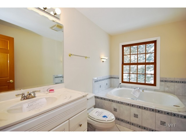 35W503 Riverside Drive St. Charles, IL 60174 - Photo 8 of 10 a bathroom with a granite countertop sink mirror vanity bathtub and next to a window