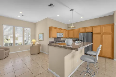 a kitchen with stainless steel appliances granite countertop a refrigerator and a stove top oven